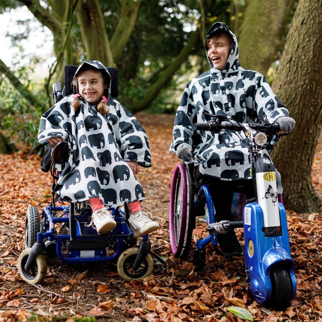 Fully waterproof adult and kids wheelchair poncho with a peaked hood to protect faces from the rain. In elephant design.