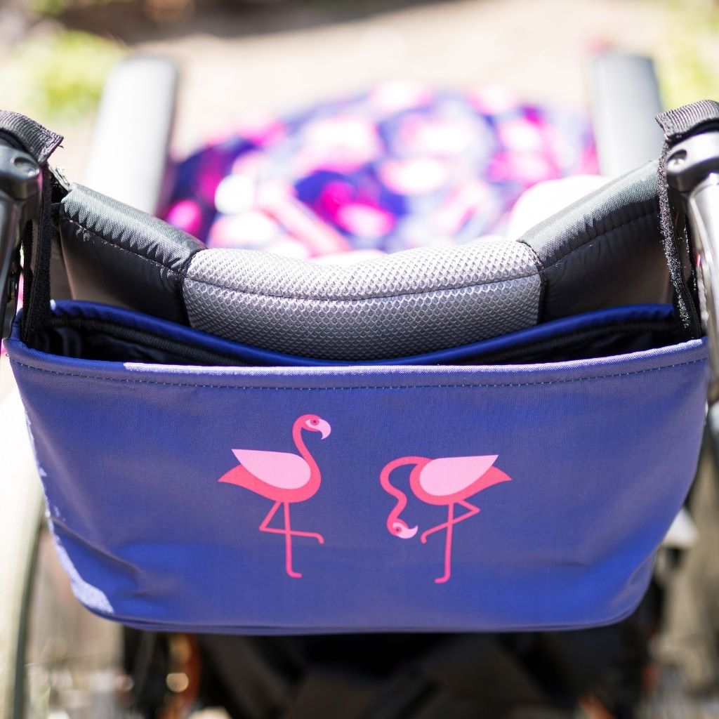 These handy wheelchair organiser bags fit on all wheelchairs, powerchairs, special needs buggies and rollators. Seen here in a pink flamingo design.