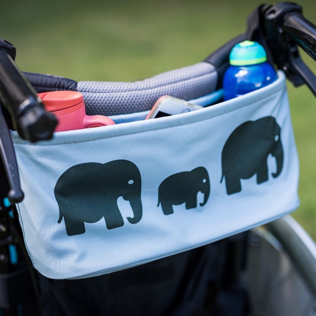 These handy wheelchair organiser bags fit on all wheelchairs, powerchairs, special needs buggies and rollators. Seen here in an elephant design holding two bottles and a phone.