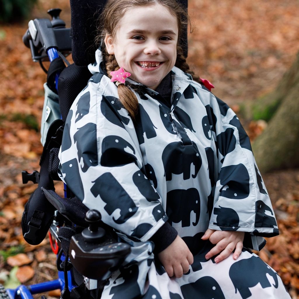 Kids Wheelchair poncho - easy to put on, fully waterproof and with peaked hood to protect faces from the rain. Seen here in an elephant design.