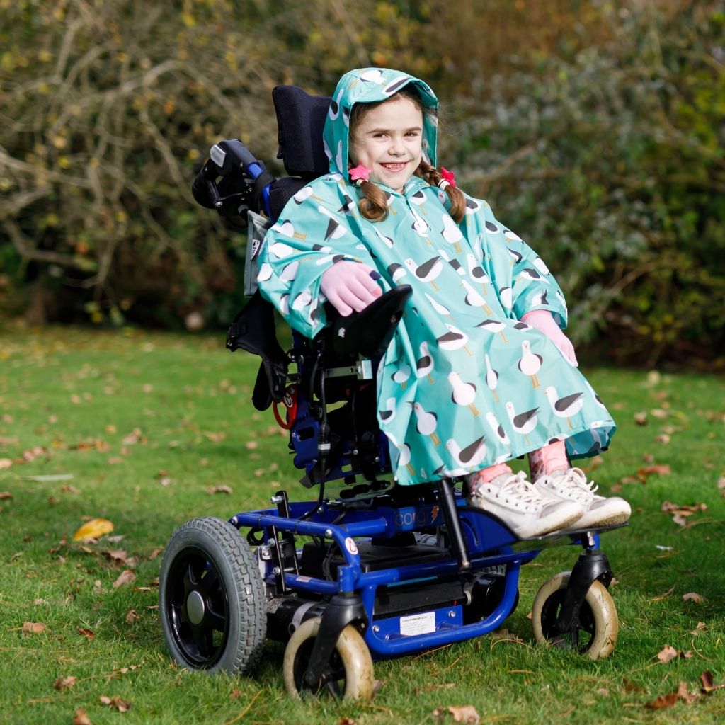 Kids Wheelchair poncho - easy to put on, fully waterproof and with peaked hood to protect faces from the rain. Seen here in a seagull design.