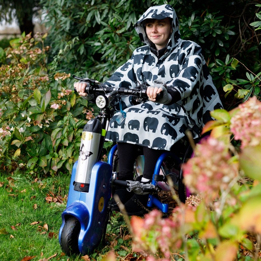 Fully waterproof adult wheelchair poncho with a peaked hood to protect faces from the rain. In elephant design.