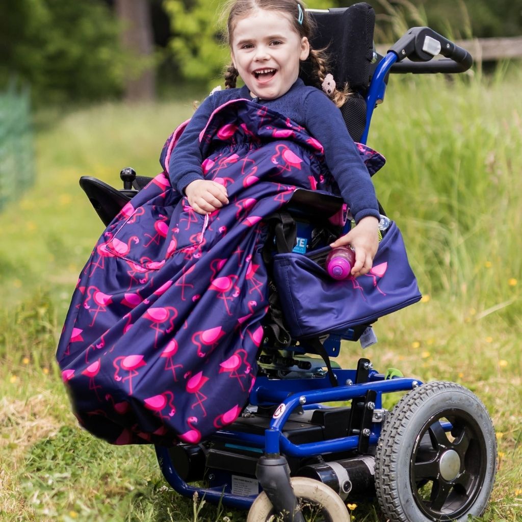 Kids fleece-lined wheelchair cosies. Waterproof, warm and easy to fit. Seen here in a flamingo design.