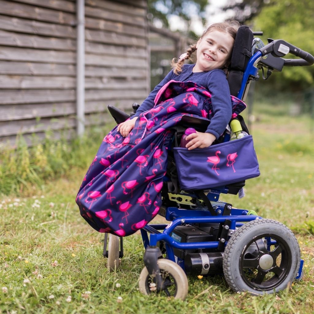 Kids fleece-lined wheelchair cosies. Waterproof, warm and easy to fit. Seen here in a flamingo design.