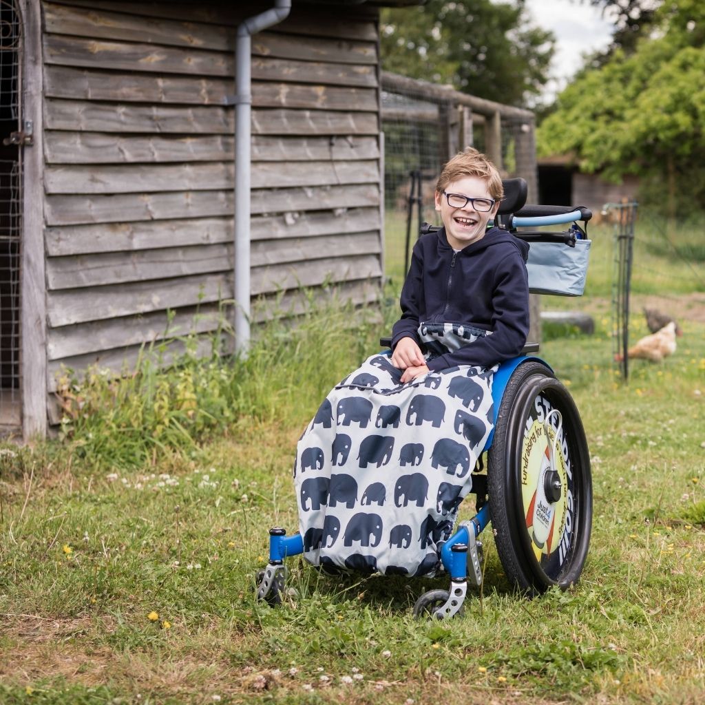 Kids fleece-lined wheelchair cosies. Waterproof, warm and easy to fit. See here in an elephant design.