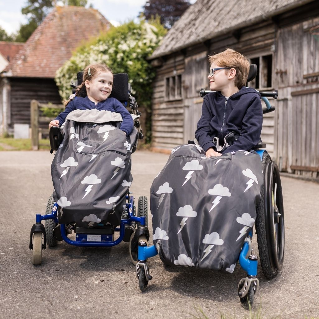 Kids fleece-lined wheelchair cosies. Waterproof, warm and easy to fit. Seen here in a silver lightning design.